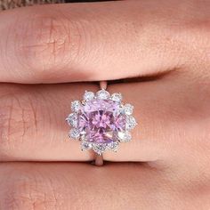 a woman's hand with a pink ring on it