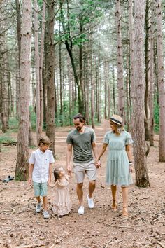 a family walking through the woods holding hands