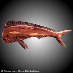 a wooden fish sculpture on a black background