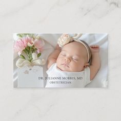 a birth announcement with a photo of a baby sleeping next to a pink flower vase