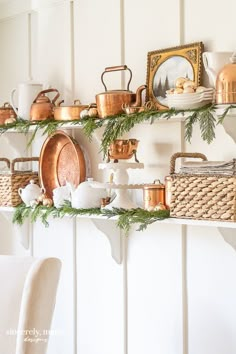 a shelf filled with pots and pans covered in greenery