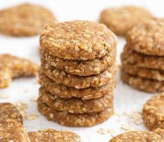 several cookies stacked on top of each other with oats scattered around them and one cookie in the middle