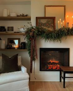 a living room filled with furniture and a fire place covered in greenery next to a fireplace