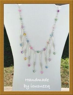 a white mannequin with multi colored beads and charms on it's neck