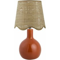 an orange table lamp with a beige shade on the base and a brown linen lampshade