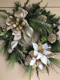 a christmas wreath with pine cones and white flowers