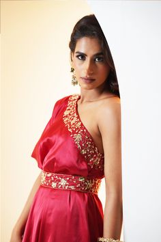 Introducing the stunning Seher Drape Cape and Flared Pants Set – a true masterpiece of traditional Indian design and modern elegance! This exquisite set features a beautiful red flared sharara pants in chiffon fabric, paired with an embroidered satin one-shoulder cape. The outfit is completed with an embroidered waist belt and an inner satin bustier, adding a touch of glamour and sophistication to the overall look.
The intricate hand embroidery on the cape showcases the impeccable craftsmanship Festive Evening Sharara Maxi Length, Bollywood Style Floor-length Palazzo Set For Evening, Festive Floor-length Palazzo Set For Evening, Elegant Red Maxi Length Set, Silk Sharara For Evening Festivals, Floor-length Silk Palazzo Set For Party, Formal Red Floor-length Dress Set, Red Floor-length Formal Dress Set, Red Formal Floor-length Set