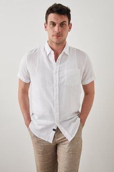 DETAILS | Lightweight cotton, short sleeve, crisp white collared buttondown shirt featuring relaxed fit, patch pocket at chest, and sustainable corozo buttons. This super soft, laidback shirt is perfect for any occasion from work to weekend. 100% Cotton. Imported. CARE | Machine Wash Cold Separately. Gentle Cycle. Do Not Bleach. Tumble Dry Low. Cool Iron If Needed. Or Dry Clean. FIT | Recommend ordering true to size. Front Body Length: 30 1/2" (Measured from Large) Model is wearing size M.Model' White Shirt For Summer Casual Gatherings, Relaxed Button-up Shirt, White Unstructured Button-up Top, White Short Sleeve Shirt With Spread Collar And Pockets, White Short Sleeve Shirt With Spread Collar Relaxed Fit, White Short Sleeve Shirt With Pockets And Spread Collar, Unstructured White Button-up Top, White Relaxed Fit Short Sleeve Shirt With Spread Collar, White Collared Shirt With Rolled Sleeves