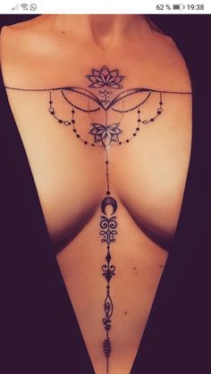 a woman's chest with an intricate tattoo design on the top and bottom part