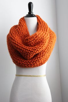 an orange knitted scarf on a mannequin