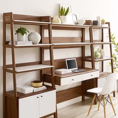 a laptop computer sitting on top of a wooden shelf next to a white chair and desk