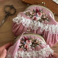 two pink purses with white lace and flowers on them