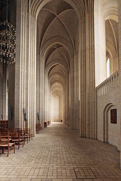 an empty cathedral with rows of chairs and chandeliers