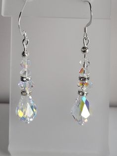 This pair of earrings feature a 8x12mm clear ab teardrop and 4mm and 6mm round Swarovski crystal beads. They are accented with silver-plated crystal rondells and sterling silver beads and have fish hook ear wires. Although these earrings are elegant, they also work well with casual outfits. Custom Orders are always welcome! Iridescent Teardrop Earrings For Wedding, Classic White Crystal Earrings, Silver Teardrop Crystal Earrings, Nickel-free Crystal Earrings For Anniversary, Silver Crystal Drop Earrings, Sparkling Sterling Silver Drop Crystal Earrings, Faceted Crystal Teardrop Earrings, White Crystal Teardrop Earrings With Sparkle, White Crystal Teardrop Earrings With Sparkling Detail