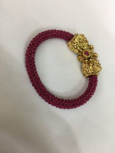 A new addition to our product line by our artisans. A beautiful piece for our traditional Indian Bride! Notice the gorgeous carving work on the twin elephant figure at the center and the red-colored beaded mesh at the base. Material: Brass and copper mix, gold plated, beads The bracelet is the same as shown in the picture and in the video. We have only one piece in this design and color and hence you get what you see in the picture. For wrist sizes 2.4- 2.6  Easily openable with a screw. Festive Red Bracelets With Zari Work, Red Jewelry With Motifs For Puja, Red Bracelets With Zari Work For Festive Season, Red Zari Work Bracelets For Festive Season, Red Zari Work Bracelet For Diwali, Traditional Red Bracelets With Zari Work, Traditional Red Bracelet With Zari Work, Traditional Red Bracelets With Intricate Design, Red Motif Jewelry For Rituals