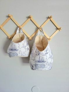 two baby shoes hanging on the wall next to a pair of wooden clothes pegs