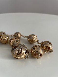 Vintage 1930s to 1940s brass necklace feature large, etched, filigree-esque balls with see-through cutouts.The balls alternate in size .  Era: 1930s -1940s Length: 20" Materials: brass , metal Condition: excellent ✩ visit the shop ✩ https://www.etsy.com/shop/Themagicstories2?ref=seller-platform-mcnav Thanks! Vintage Brass Necklace With Round Beads, Vintage Antique Gold Round Beads Jewelry, Vintage Brass Jewelry With Round Beads, Retro Gold Jewelry With Antique Finish, Vintage Gold Filigree Necklace, Vintage Metal Necklace With Round Beads, Vintage Metal Necklaces With Round Beads, Vintage Necklace With Round Metal Beads, Antique Gold Filigree Brass Necklace