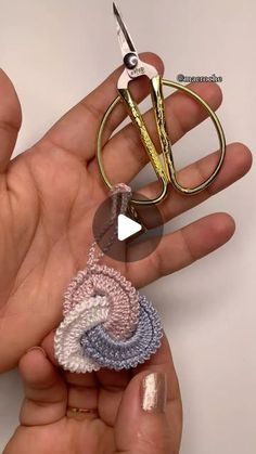 someone is holding two pairs of scissors in their hand, and one pair has been made out of crochet