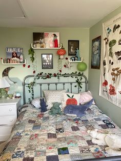 a bed with a quilt on top of it and stuffed animals sitting on the pillows