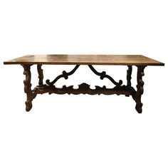 an old wooden table with ornate carvings on the top and bottom, against a white background