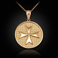 a gold pendant with an image of a cross in the center on a black background