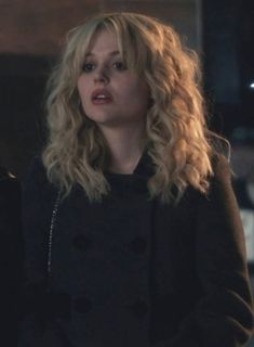 a woman with blonde hair wearing a black jacket