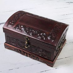 an ornate wooden box sitting on top of a white table