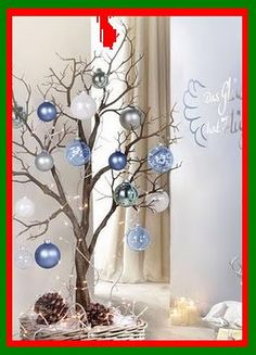 a christmas tree with blue and white ornaments in a basket next to a candle holder