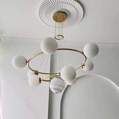 a chandelier hanging from the ceiling in a room with white walls and flooring