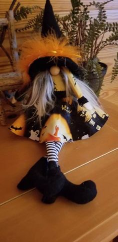 a witch doll sitting on top of a wooden table