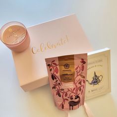 a candle, tea bag and gift box sitting on a white counter top next to it