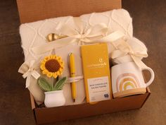 a box with some items in it and a sunflower on the table next to it