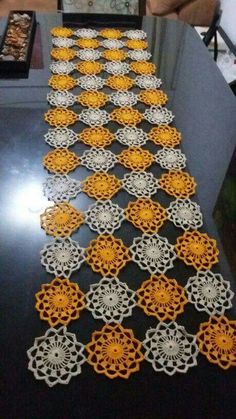 the table is decorated with yellow and white crocheted doily on black wood