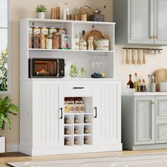 a kitchen with white cabinets and appliances in it