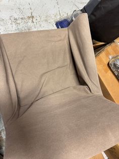 a brown chair sitting on top of a wooden floor next to a pile of boxes