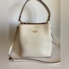 Coach Small Town Bucket Bag Leather Crossbody 1011 In Chalk White $350. Polished Pebble Leather Center Zip Compartment Snap Closure Handle With 6 3/4″ Drop Detachable Strap With 22″ Drop For Shoulder Or Crossbody Wear 8 1/2″ (L) X 8 3/4″ (H) X 4″ (W) Classic Cream Bag For Everyday Luxury, Classic Luxury Bucket Bag With Top Handle, Everyday Luxury Bags With Gold-tone Hardware, Classic Cream Shoulder Bag For Everyday Luxury, Luxury Everyday Rectangular Bucket Bag, Luxury Rectangular Bucket Bag For Everyday, Luxury Rectangular Bucket Bag, Elegant White Bucket Bag For Evening, Elegant White Evening Bucket Bag