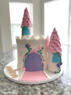 a cake that looks like a castle with pink and purple frosting on the outside