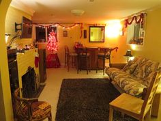 a living room filled with furniture next to a fire place covered in christmas lights and decorations