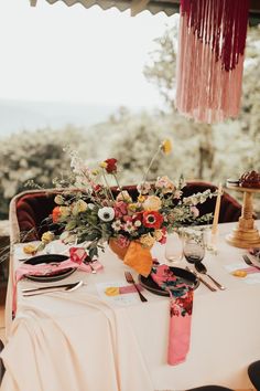 the table is set with flowers and plates