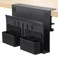 three black plastic cups and holders on a wooden table