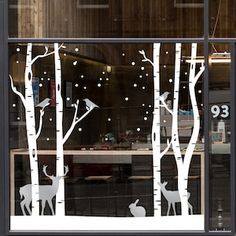 the window is decorated with white trees and deer