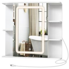 a bathroom mirror that is on top of a white shelf next to a bathtub