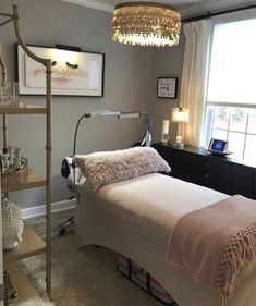 a bed sitting under a window next to a lamp