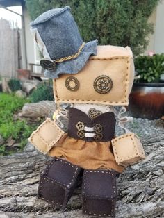 a small stuffed animal wearing a hat and boots on top of a tree stump in front of a house