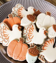 decorated cookies in the shape of turkeys and pumpkins on a silver platter