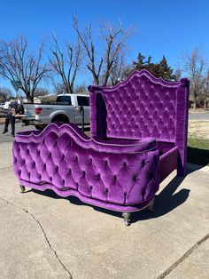 a purple couch sitting on top of a sidewalk