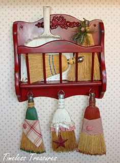 three brooms are hanging on the wall in front of a shelf with other items