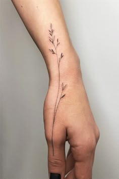 a woman's hand with a small flower tattoo on the left side of her arm