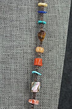 This turquoise, coral, lapis, amber, spiny oyster, mother of pearl, abalone, jasper, onyx, amethyst and sterling silver necklace was made by Navajo artisan Helen Tsosie.Necklace: 28" with an additional 2" extender chainWidth: 1/8" to 3/8"Free shipping on all orders! We ship with USPS and always include tracking. All orders ship within a day of payment.Returns are accepted up to 30 days after you receive your order. Just send us a message. Our shop offers cash back or store credit. The item must be returned in new condition. Coral And Pearl Necklace, Brown Turquoise Necklace With Natural Stones, Spiritual Style, Southwestern Brown Hand-strung Jewelry, Multicolor Gemstone Southwestern Necklace, Southwestern Multicolor Gemstone Necklace, Southwestern Brown Turquoise Necklace With Natural Stones, Southwestern Style Multicolor Gemstone Necklace, Southwestern Multicolor Gemstone Beaded Necklaces, Southwestern Style Multicolor Necklaces With Natural Stones