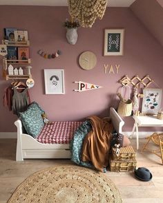 a bedroom with pink walls and pictures on the wall